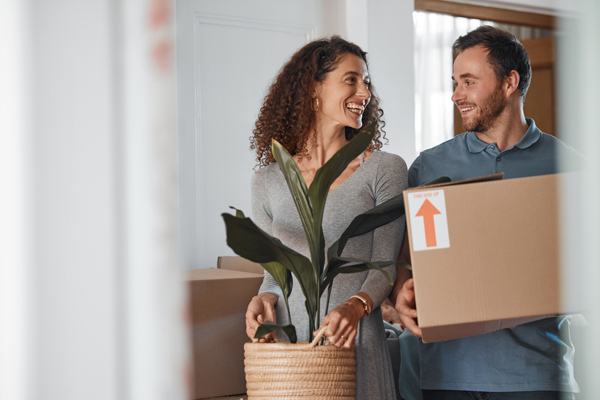 happy couple moving boxes and houseplants during relocation 3 moving tips